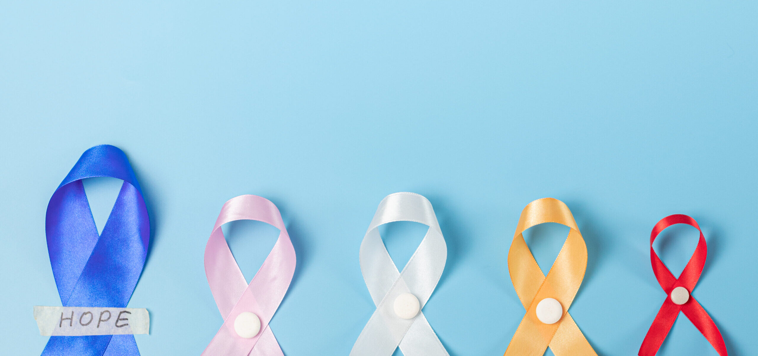 Five multi-colored emblem ribbons on a blue background.